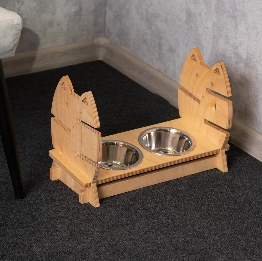 Sleek and modern elevated cat feeder made of light wood, featuring two stainless steel bowls.